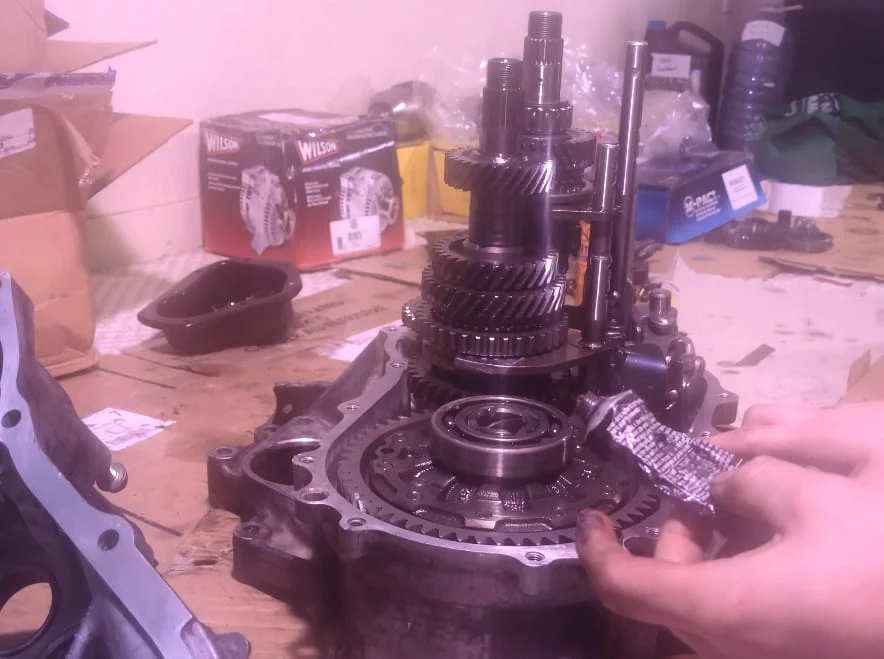 Applying black RTV sealant to the transmission bell housing mating surface